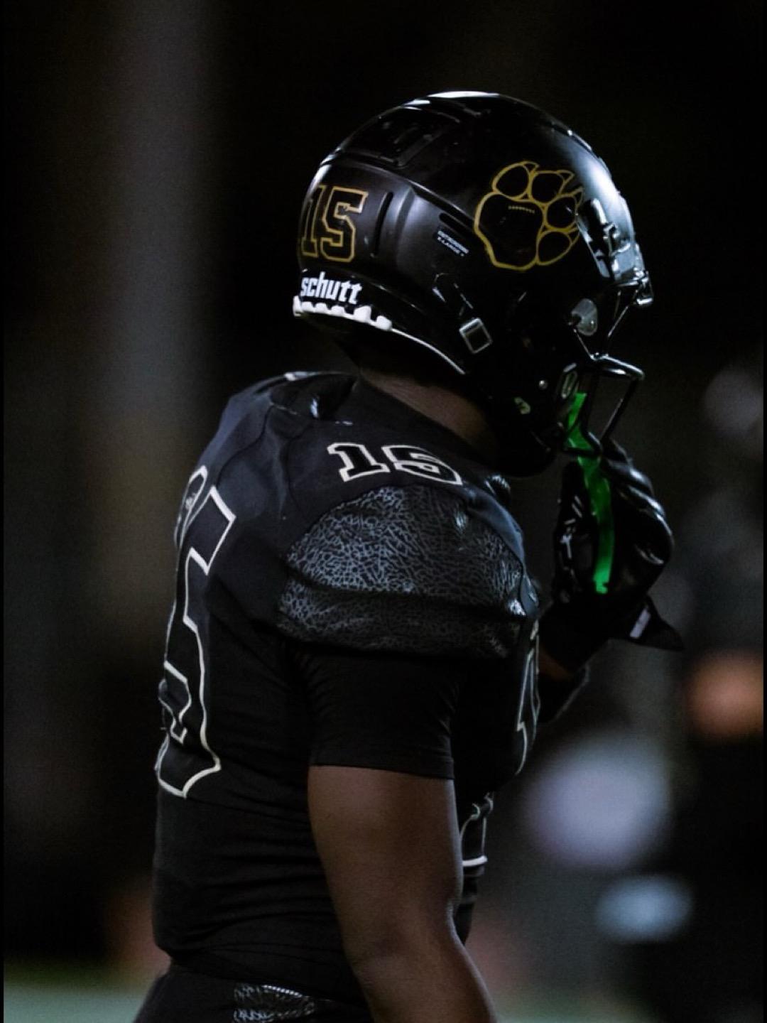 Ekesiobi Ofomata in football gear, silhouette under red light